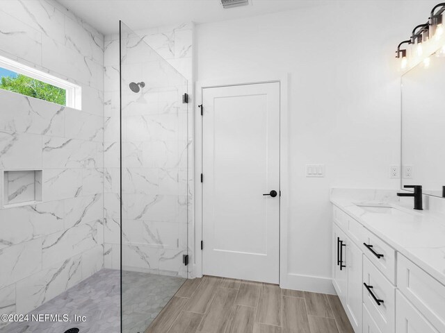 bathroom with vanity and a tile shower