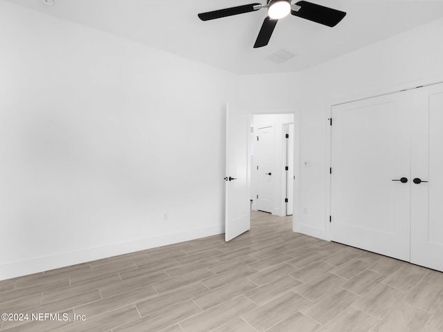 unfurnished bedroom with ceiling fan, a closet, and light hardwood / wood-style flooring