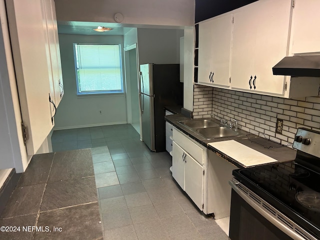 kitchen with stainless steel appliances, sink, tasteful backsplash, light tile patterned floors, and white cabinetry