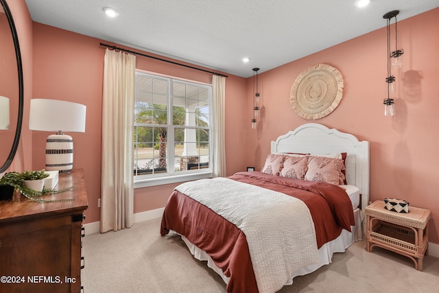 bedroom featuring a textured ceiling and light carpet