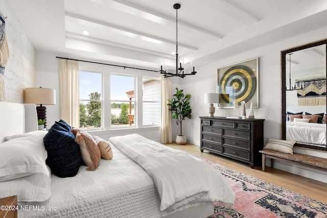 bedroom with wood-type flooring and an inviting chandelier