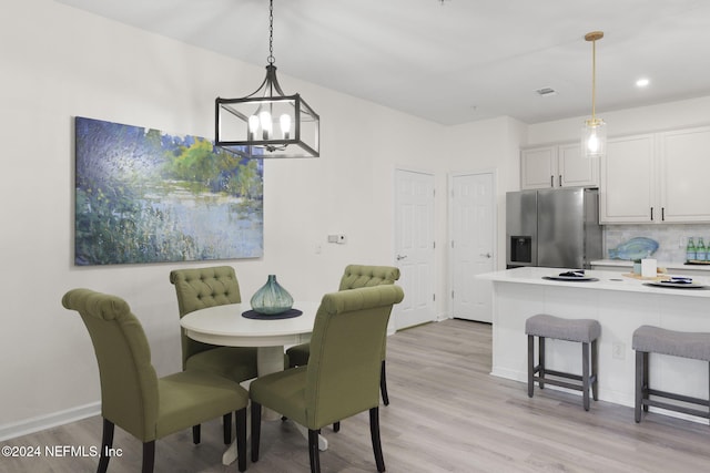 dining area with a chandelier and light hardwood / wood-style flooring