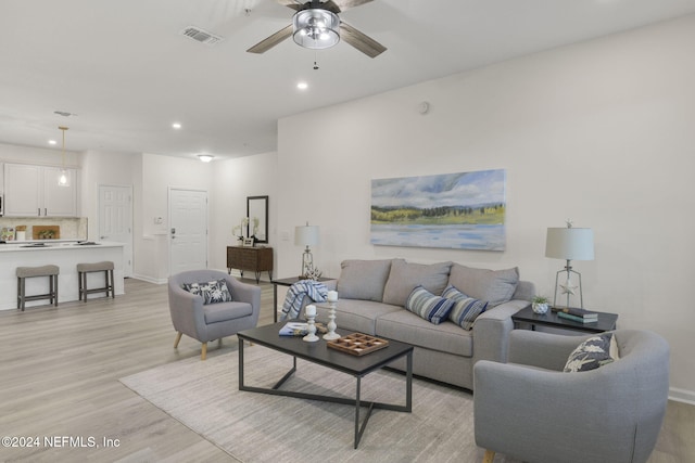 living room with ceiling fan and light hardwood / wood-style floors