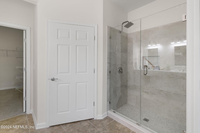 bathroom with tile patterned flooring and a shower with shower door