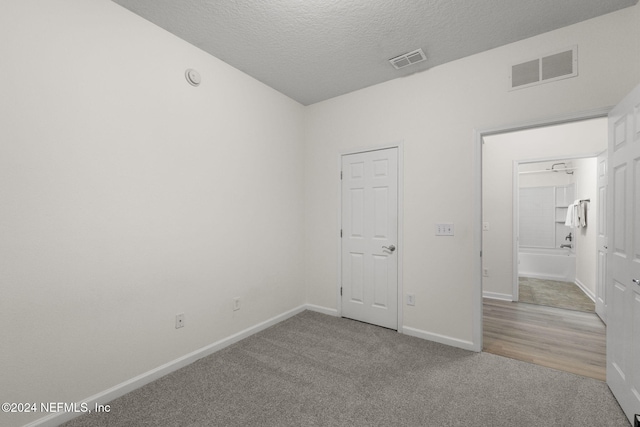 carpeted empty room with a textured ceiling