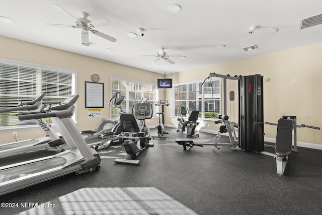 gym with a textured ceiling and ceiling fan