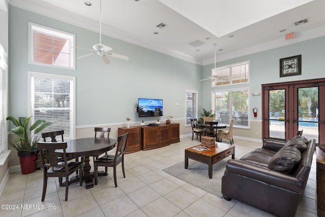 tiled living room with a high ceiling, ornamental molding, french doors, and ceiling fan