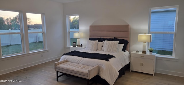 bedroom with light wood finished floors and baseboards