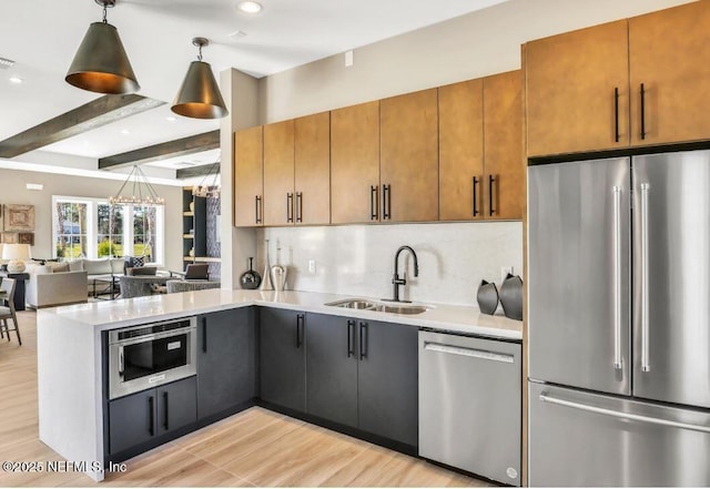 kitchen featuring stainless steel appliances, backsplash, a sink, and light countertops