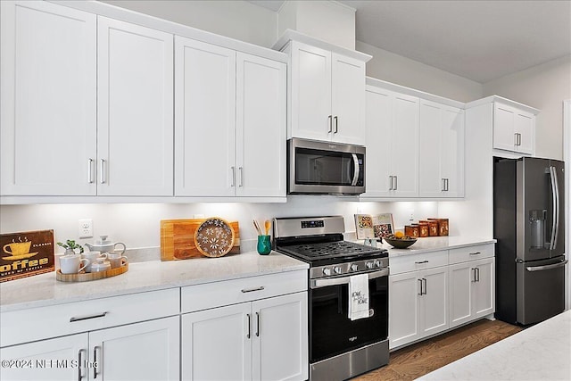 kitchen featuring white cabinets, appliances with stainless steel finishes, and dark hardwood / wood-style floors