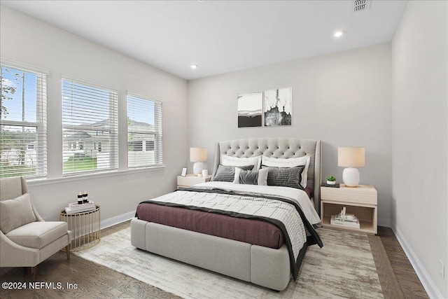 bedroom with multiple windows and hardwood / wood-style floors