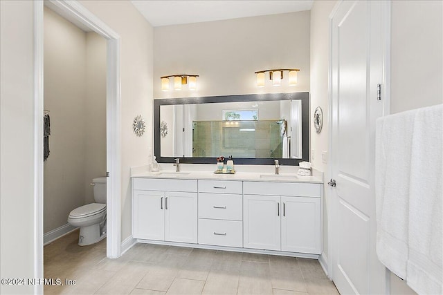 bathroom featuring vanity, toilet, and a shower with door