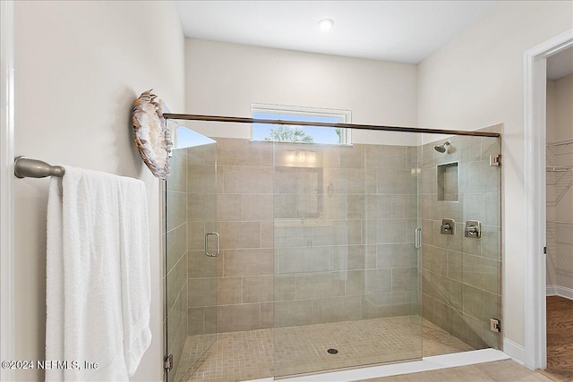 bathroom with an enclosed shower and hardwood / wood-style floors