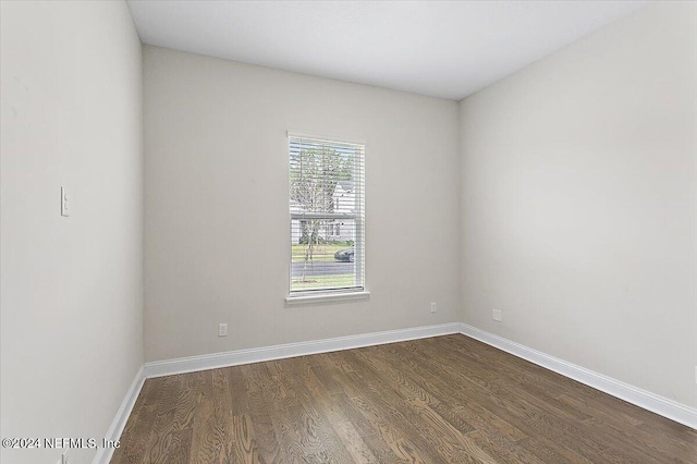 empty room with dark hardwood / wood-style flooring