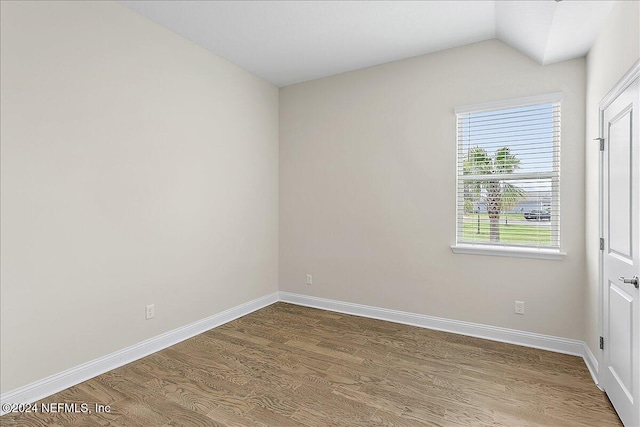 empty room featuring hardwood / wood-style flooring and lofted ceiling