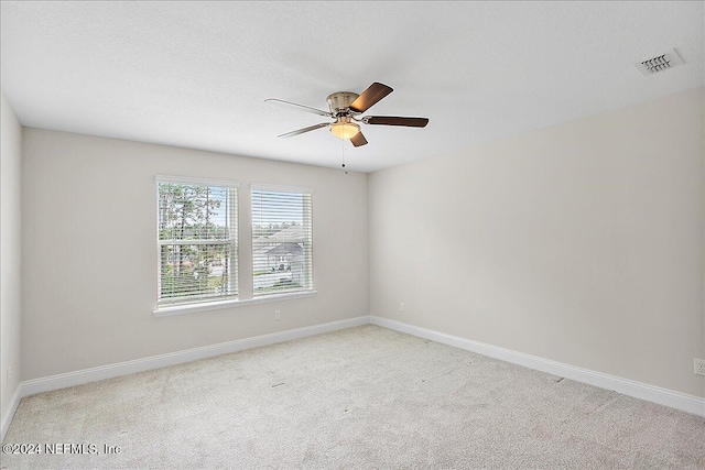 carpeted spare room with ceiling fan