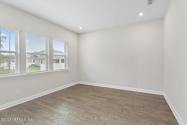 empty room with plenty of natural light and dark hardwood / wood-style flooring