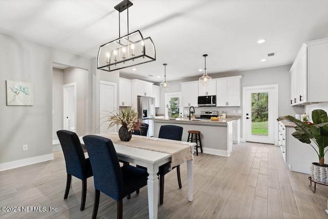 dining space featuring light hardwood / wood-style floors and sink