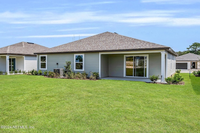 back of property with central AC unit and a yard