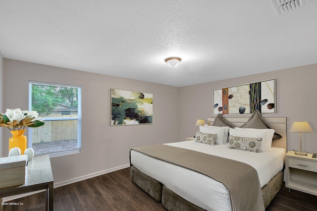 bedroom with dark wood-type flooring and a textured ceiling