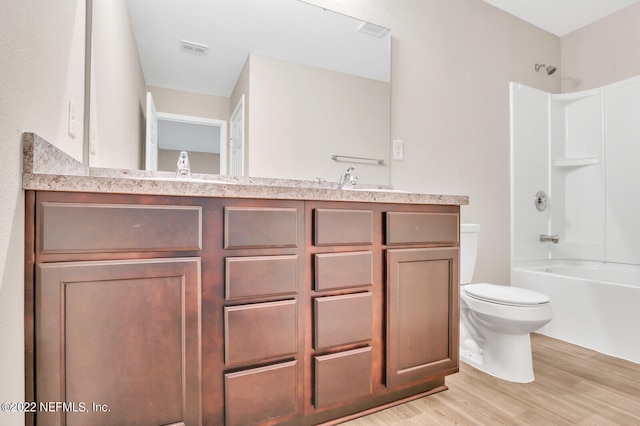 full bathroom featuring toilet, vanity, hardwood / wood-style flooring, and shower / bathing tub combination