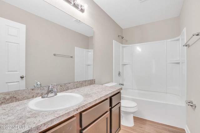 full bathroom with washtub / shower combination, wood-type flooring, toilet, and vanity