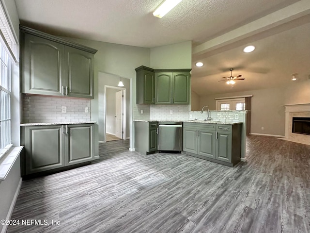 kitchen featuring kitchen peninsula, ceiling fan, backsplash, dishwasher, and dark hardwood / wood-style flooring