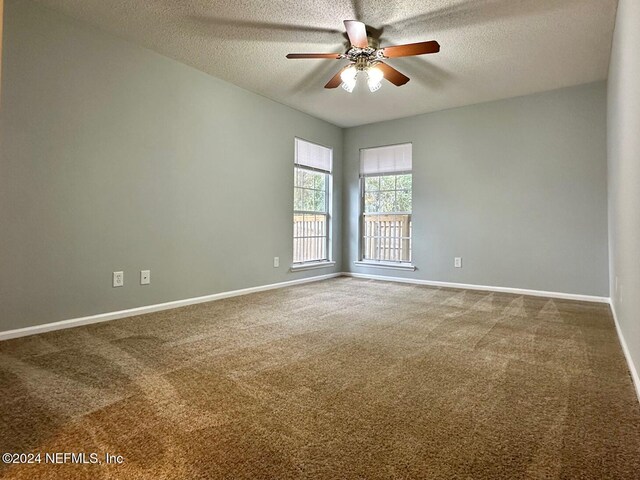 carpeted spare room with a textured ceiling and ceiling fan