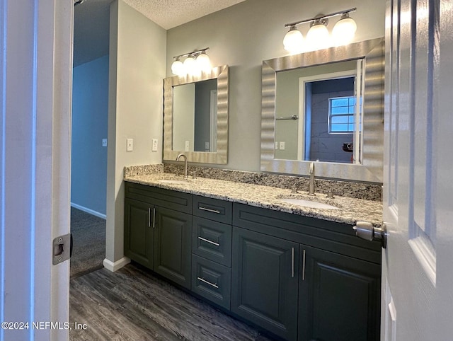 bathroom with vanity, wood-type flooring, and a textured ceiling