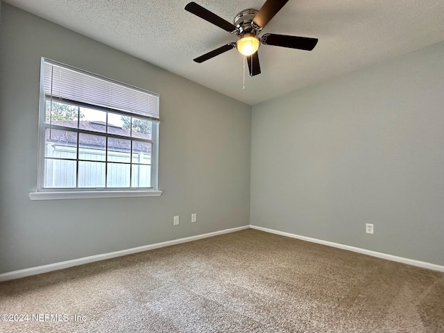 carpeted spare room with a textured ceiling and ceiling fan