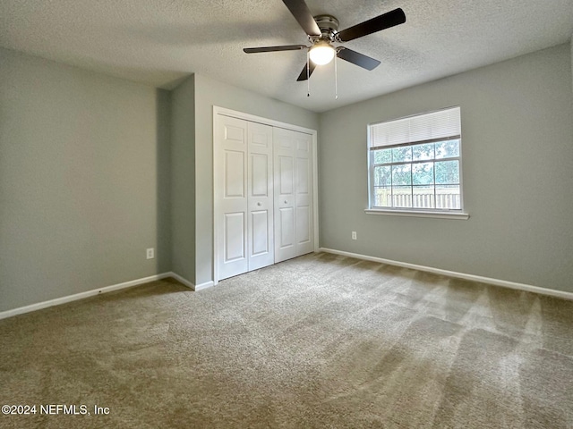 unfurnished bedroom with a closet, carpet, a textured ceiling, and ceiling fan