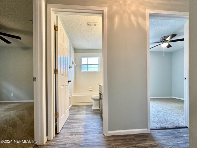 hallway featuring a textured ceiling and wood-type flooring