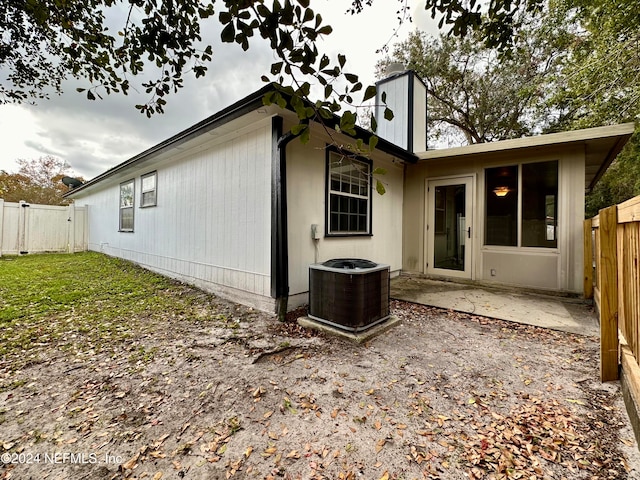 rear view of property with central AC unit and a patio