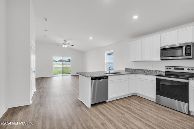 kitchen featuring white cabinetry, stainless steel appliances, sink, and light hardwood / wood-style flooring