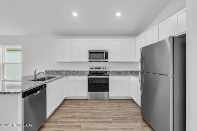 kitchen featuring stainless steel appliances, sink, white cabinets, kitchen peninsula, and light hardwood / wood-style flooring