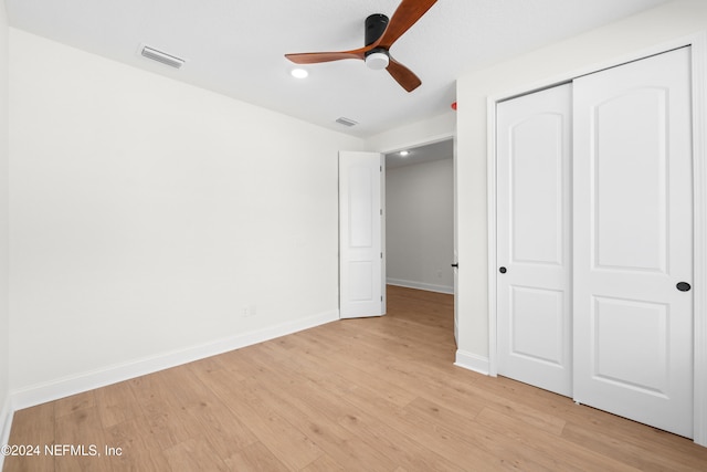 unfurnished bedroom featuring a closet, light hardwood / wood-style flooring, and ceiling fan