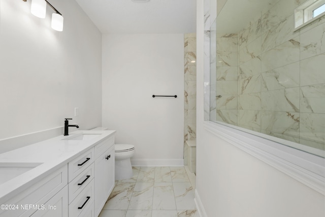 bathroom with vanity, toilet, and tiled shower