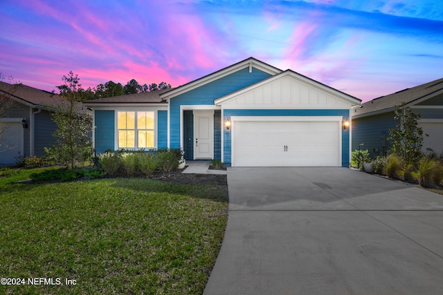 ranch-style house with a garage and a yard