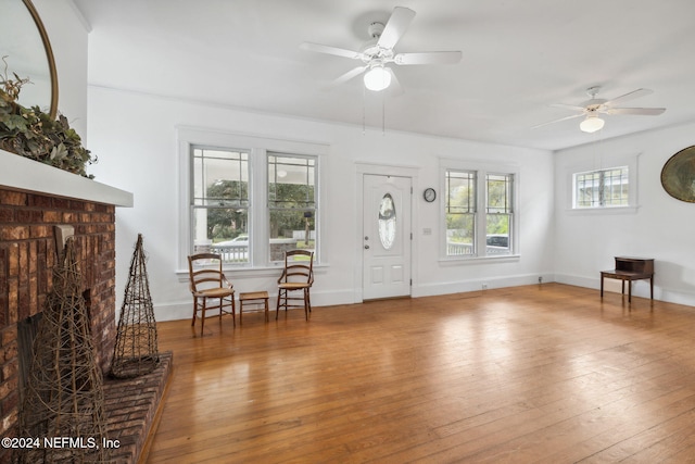 living room featuring a brick fireplace, ceiling fan, and hardwood / wood-style flooring