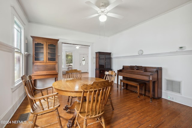 dining room with ornamental molding, a wealth of natural light, dark wood-type flooring, and ceiling fan