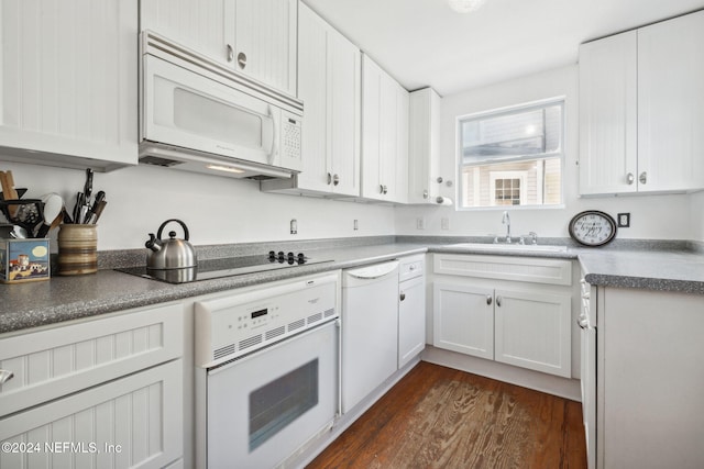 kitchen with white cabinetry, sink, dark wood-type flooring, and white appliances