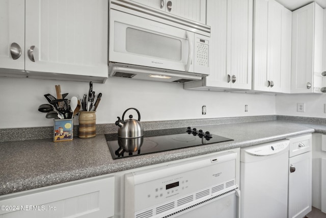 kitchen with white cabinetry and white appliances