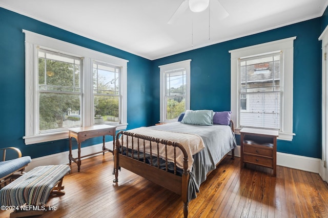 bedroom featuring multiple windows, ceiling fan, and hardwood / wood-style flooring