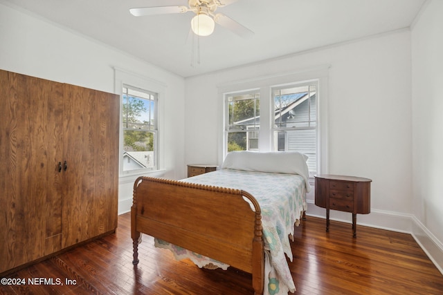 bedroom with dark hardwood / wood-style floors, ceiling fan, and crown molding