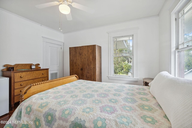 bedroom with ceiling fan, hardwood / wood-style floors, and ornamental molding