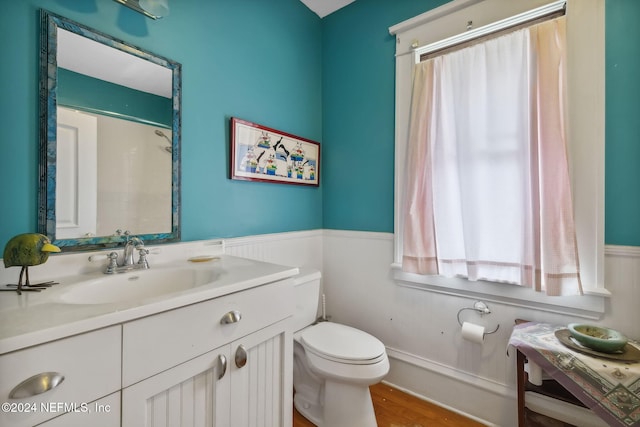 bathroom featuring hardwood / wood-style flooring, vanity, toilet, and walk in shower