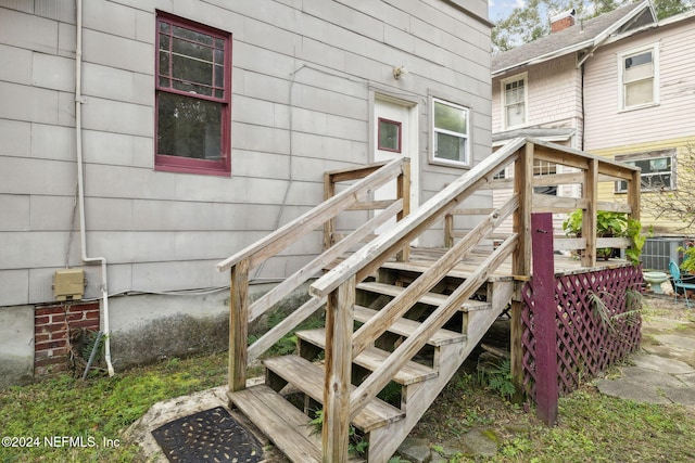 doorway to property featuring cooling unit and a wooden deck