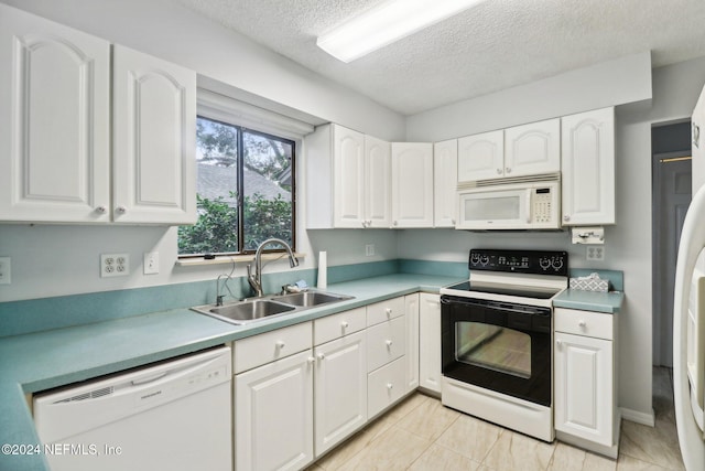 kitchen featuring a textured ceiling, white appliances, sink, light tile patterned floors, and white cabinetry