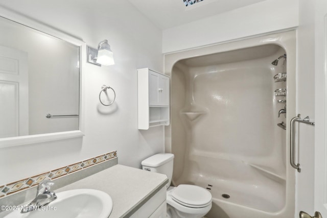 bathroom with toilet, vanity, and walk in shower