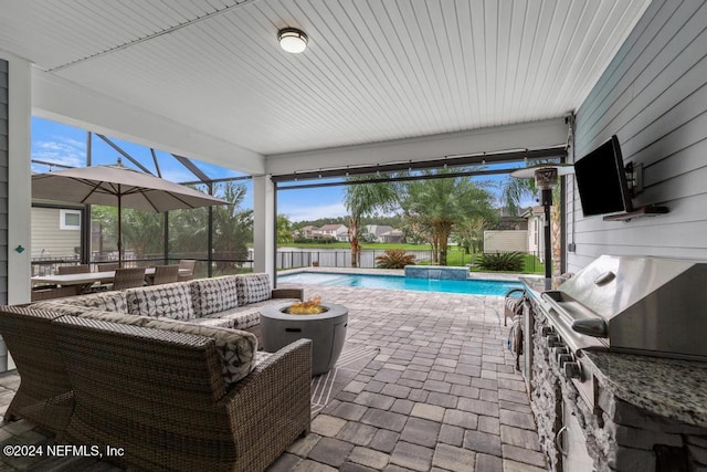 view of patio with an outdoor kitchen, a lanai, a fenced in pool, and pool water feature